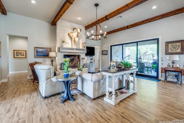 living room featuring beam ceiling, light wood finished floors, a notable chandelier, and visible vents