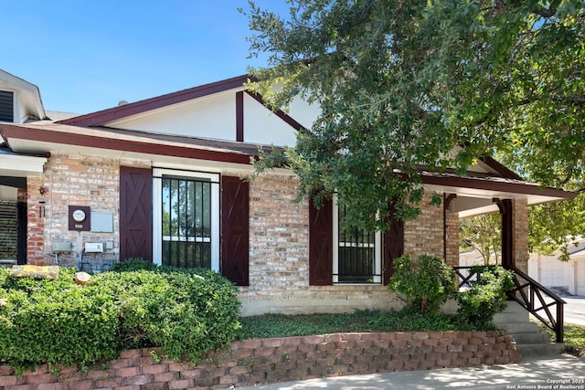 exterior space with a porch and brick siding