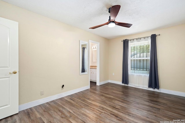 empty room with a textured ceiling, baseboards, a ceiling fan, and wood finished floors