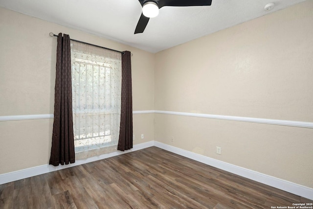 unfurnished room featuring wood finished floors, baseboards, and a ceiling fan