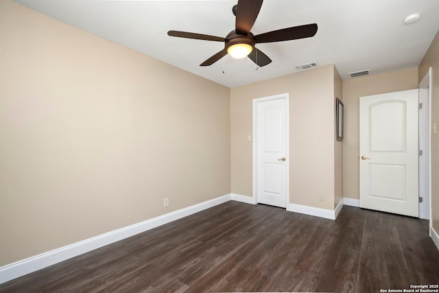 unfurnished bedroom featuring dark wood-type flooring, baseboards, a ceiling fan, and visible vents