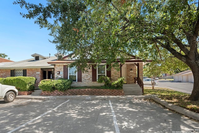 view of front of property with uncovered parking and brick siding