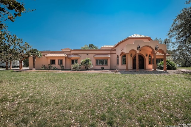 rear view of property with a lawn and stucco siding