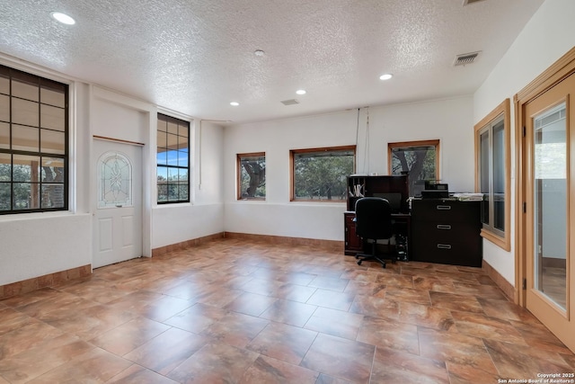 office area with a textured ceiling, baseboards, and visible vents