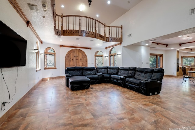 living room featuring recessed lighting, a towering ceiling, visible vents, and baseboards