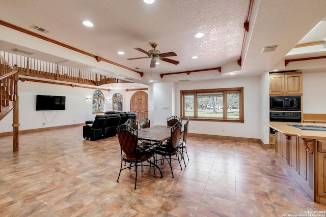 dining room featuring stairway, a textured ceiling, visible vents, a tray ceiling, and ceiling fan