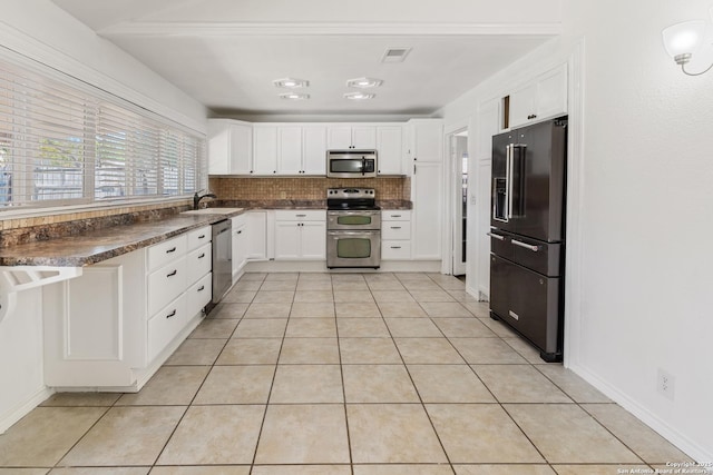 6826 Horwich, San Antonio, TX 78239 - kitchen featuring light tile patterned floors, visible vents, dark countertops, appliances with stainless steel finishes, and backsplash