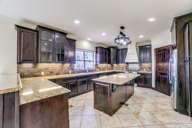 12022 Del Rio Run, San Antonio, TX 78245 - kitchen featuring custom exhaust hood, dark brown cabinetry, tasteful backsplash, stainless steel appliances, and a sink