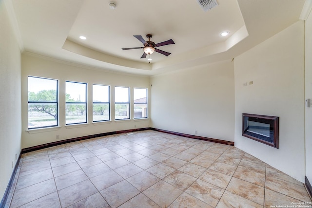 12022 Del Rio Run, San Antonio, TX 78245 - unfurnished living room featuring ceiling fan, a glass covered fireplace, visible vents, a raised ceiling, and baseboards