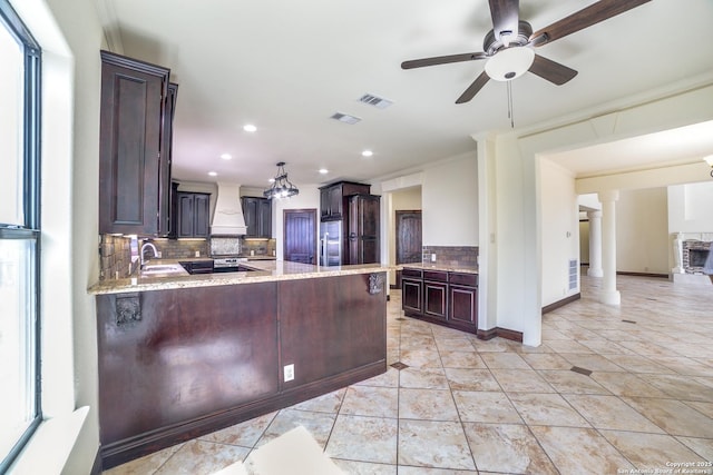 12022 Del Rio Run, San Antonio, TX 78245 - kitchen featuring stainless steel fridge, premium range hood, visible vents, decorative backsplash, and a sink