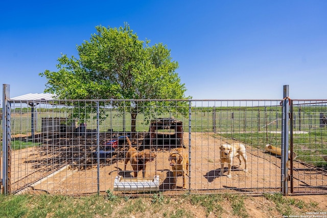 view of yard featuring an outbuilding, fence, and a rural view