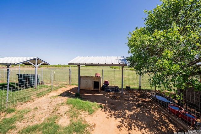 view of yard featuring exterior structure, fence, and an outdoor structure