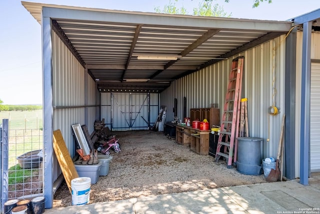 view of vehicle parking with an exterior structure and an attached carport