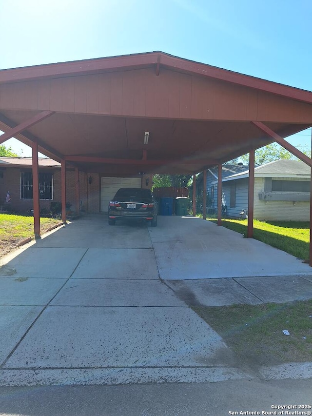 view of car parking featuring a carport, an attached garage, and driveway