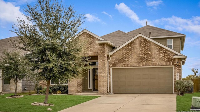 view of front of house featuring concrete driveway, cooling unit, a front yard, brick siding, and a garage