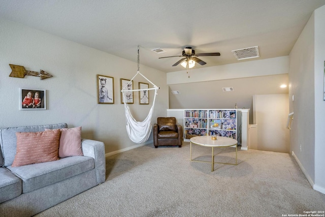 carpeted living area with visible vents, baseboards, and a ceiling fan
