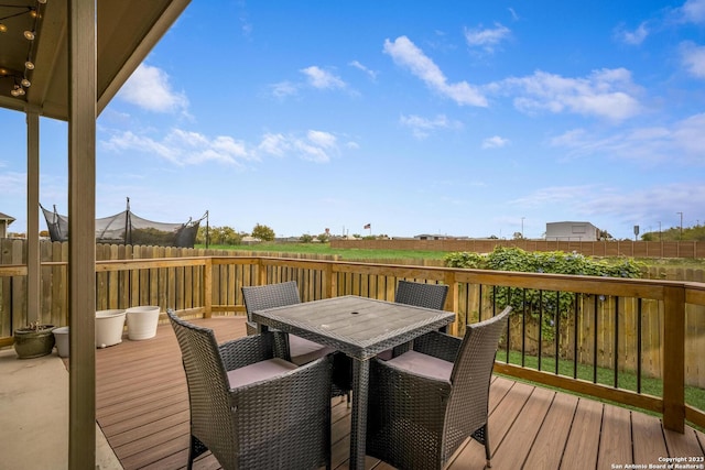 wooden deck with outdoor dining space and fence