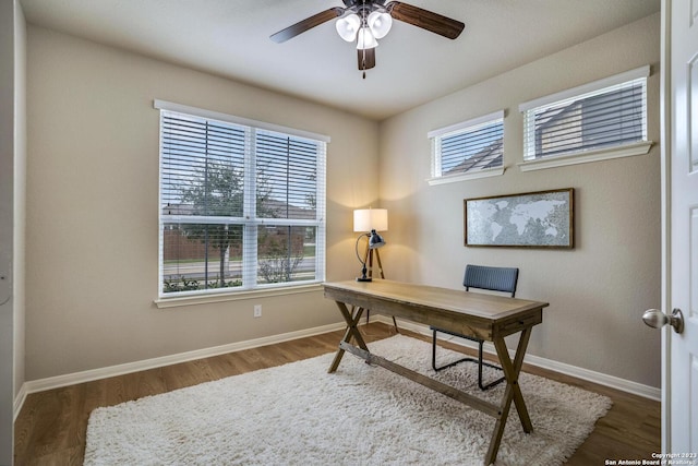 office space featuring wood finished floors, ceiling fan, and baseboards