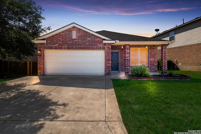 single story home featuring brick siding, an attached garage, a front lawn, and concrete driveway