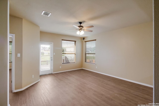 unfurnished room with visible vents, baseboards, a ceiling fan, and wood finished floors