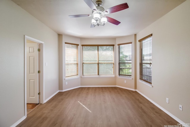 spare room with baseboards, a ceiling fan, and wood finished floors