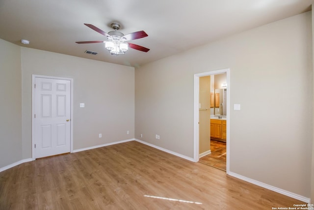 spare room featuring visible vents, ceiling fan, light wood finished floors, and baseboards