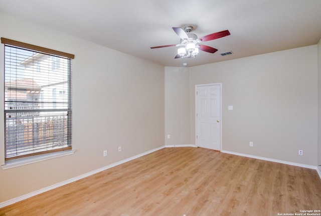 empty room with visible vents, baseboards, a ceiling fan, and light wood-style flooring