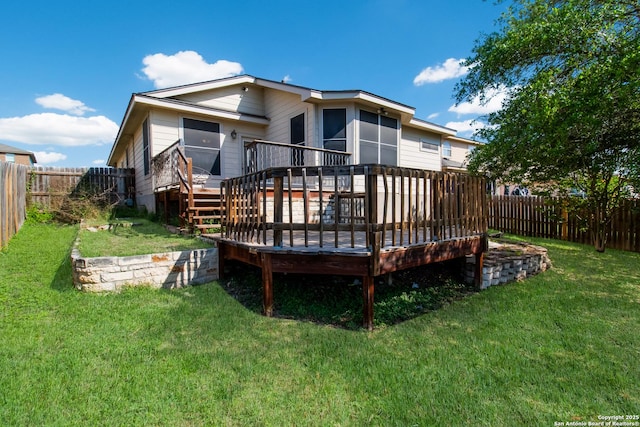 back of property with a fenced backyard, a wooden deck, and a lawn