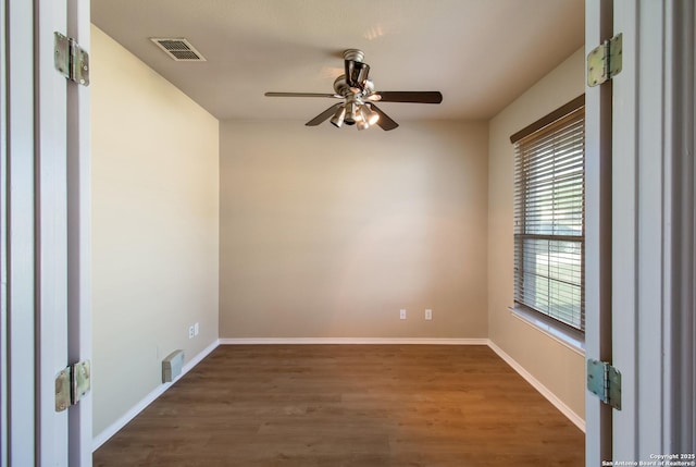 empty room featuring wood finished floors, ceiling fan, baseboards, and visible vents