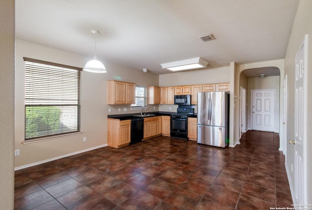 kitchen with light brown cabinets, black appliances, visible vents, arched walkways, and a sink