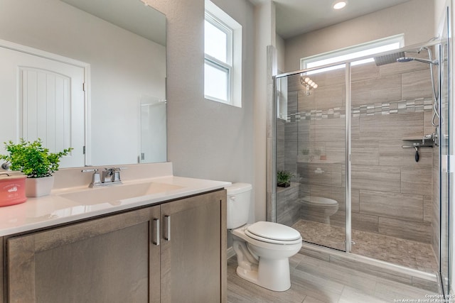 full bath with toilet, a stall shower, and vanity