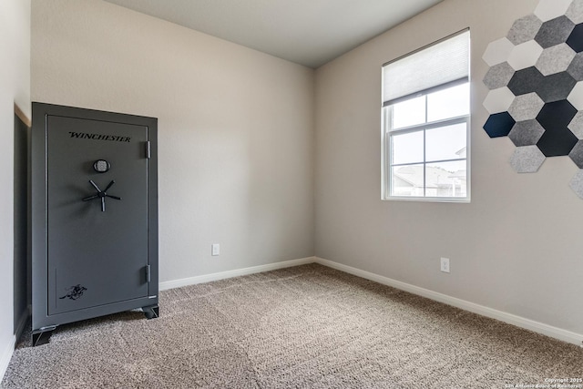 carpeted spare room featuring baseboards