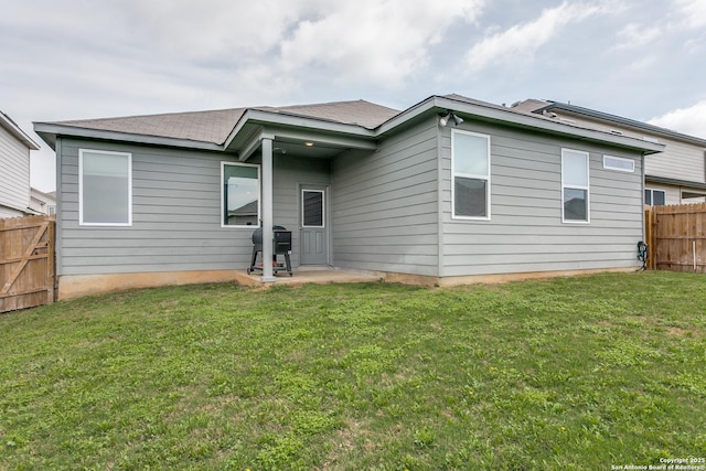 back of property featuring a yard, a patio area, and fence