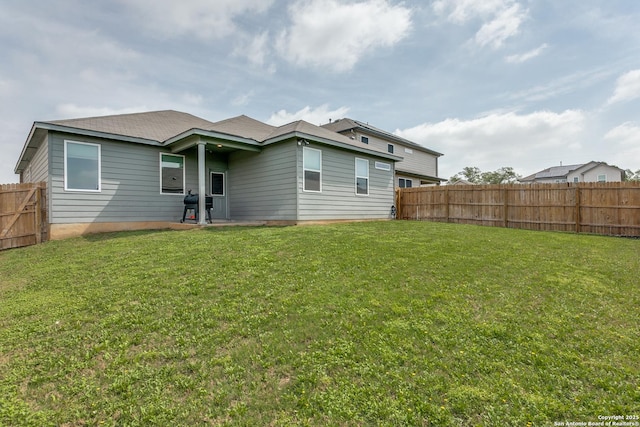 back of property featuring a fenced backyard and a lawn