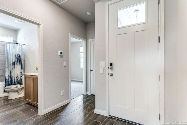foyer with visible vents, baseboards, and wood tiled floor