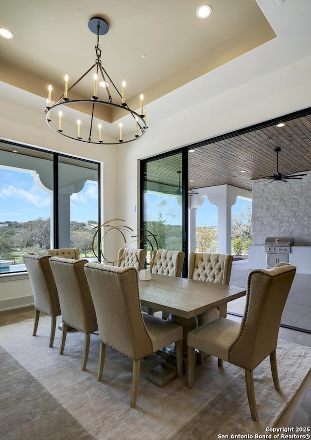 dining space featuring a raised ceiling, a notable chandelier, and recessed lighting