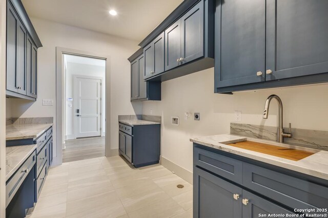 kitchen with a sink, baseboards, recessed lighting, and light stone counters