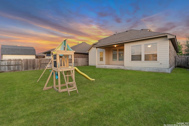 14047 Pikesdale, San Antonio, TX 78253 - back of property at dusk featuring roof with shingles, a fenced backyard, a playground, and a lawn