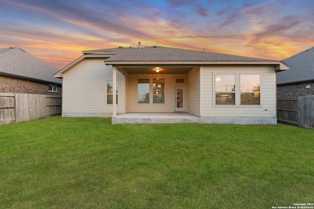 14047 Pikesdale, San Antonio, TX 78253 - back of house at dusk featuring a patio, a shingled roof, a fenced backyard, and a yard