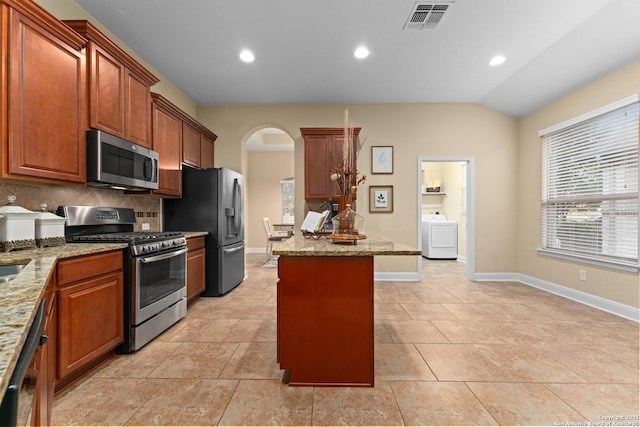14047 Pikesdale, San Antonio, TX 78253 - kitchen with washer / clothes dryer, tasteful backsplash, visible vents, appliances with stainless steel finishes, and arched walkways