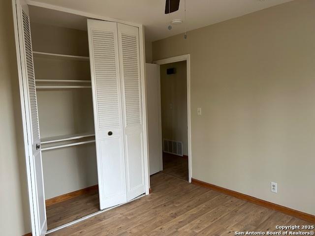 7834 Sun Frst, San Antonio, TX 78239 - unfurnished bedroom featuring a closet, baseboards, visible vents, ceiling fan, and wood finished floors