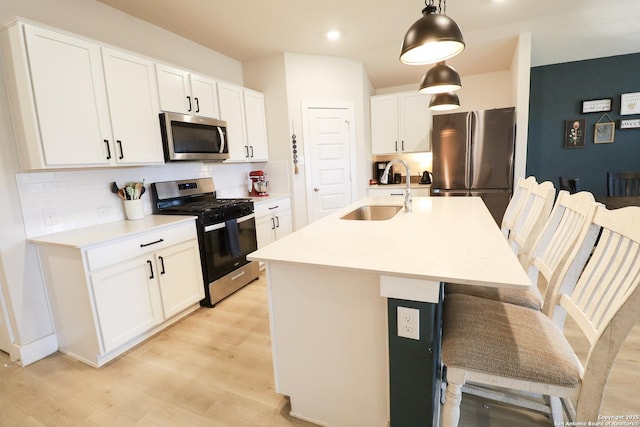 5544 Jewel, San Antonio, TX 78266 - kitchen with appliances with stainless steel finishes, light wood-type flooring, a kitchen bar, decorative backsplash, and a sink