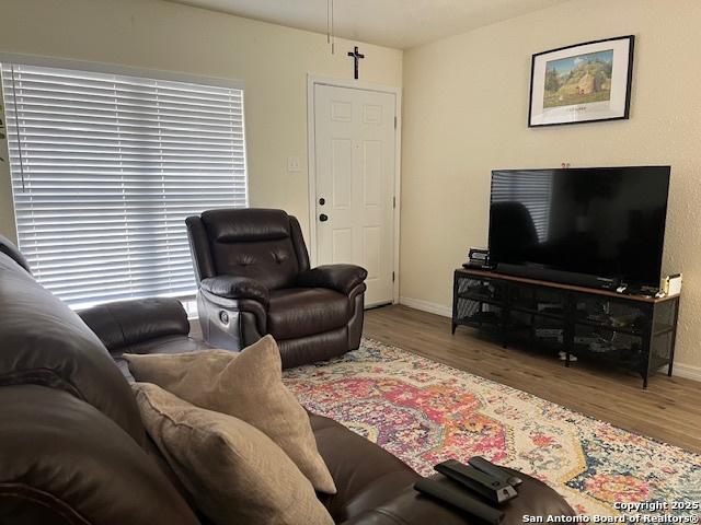 living area featuring baseboards and wood finished floors