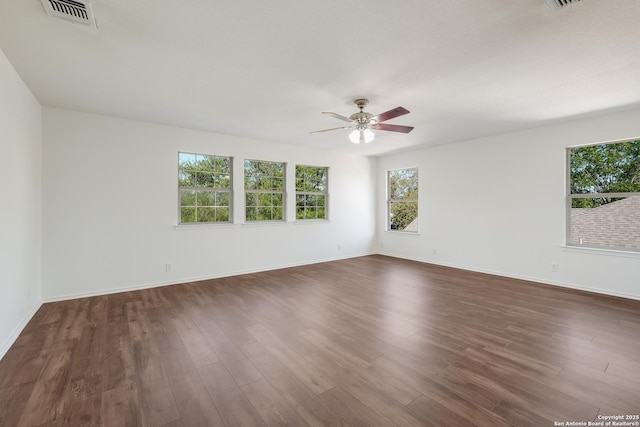 spare room with ceiling fan, baseboards, dark wood-style floors, and visible vents