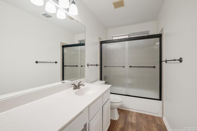 full bathroom with toilet, wood finished floors, vanity, and visible vents