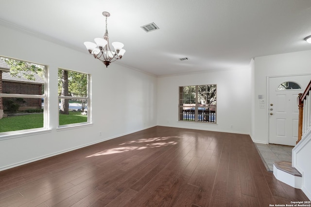 interior space with a chandelier, visible vents, and wood finished floors