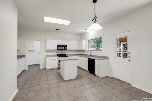 kitchen with light countertops, a kitchen island, white cabinets, decorative light fixtures, and black appliances