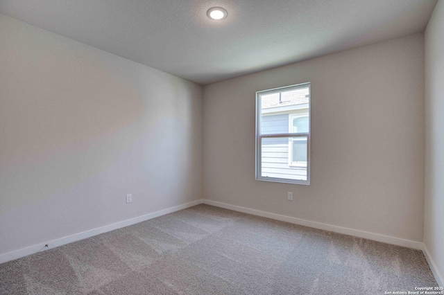 empty room with light colored carpet and baseboards