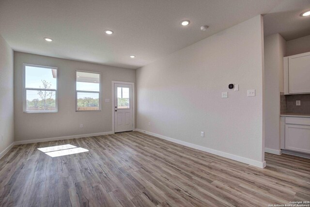 interior space with light wood-style flooring, recessed lighting, and baseboards