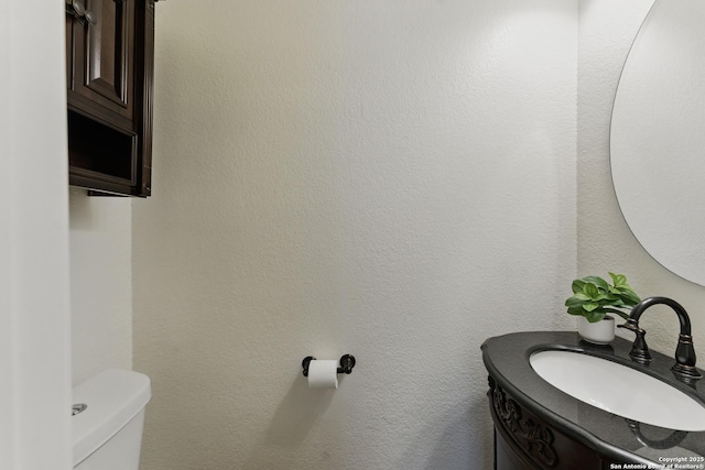 half bathroom with toilet and vanity